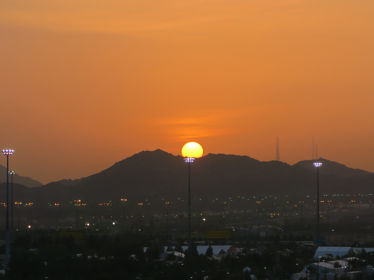 The sun sets behind the mountain of Arafah
